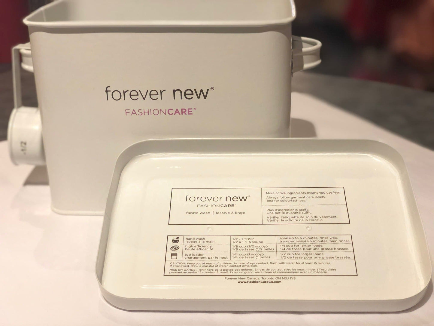 Laundry Room Tin on display in store, front view product image.