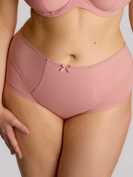 Person wearing pink high-waisted underwear and bra set on a plain background