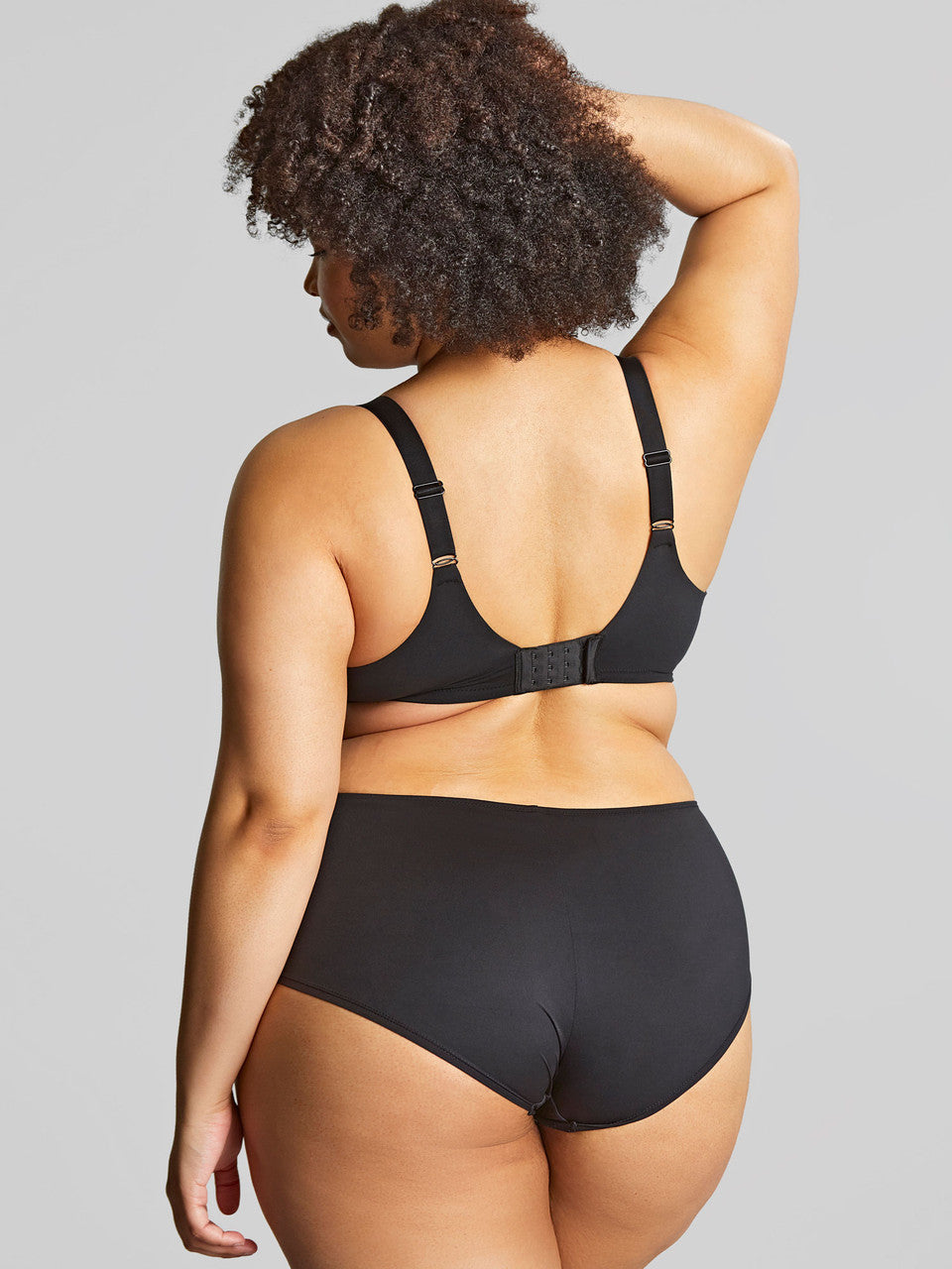 Person wearing a black bikini set on a gray background