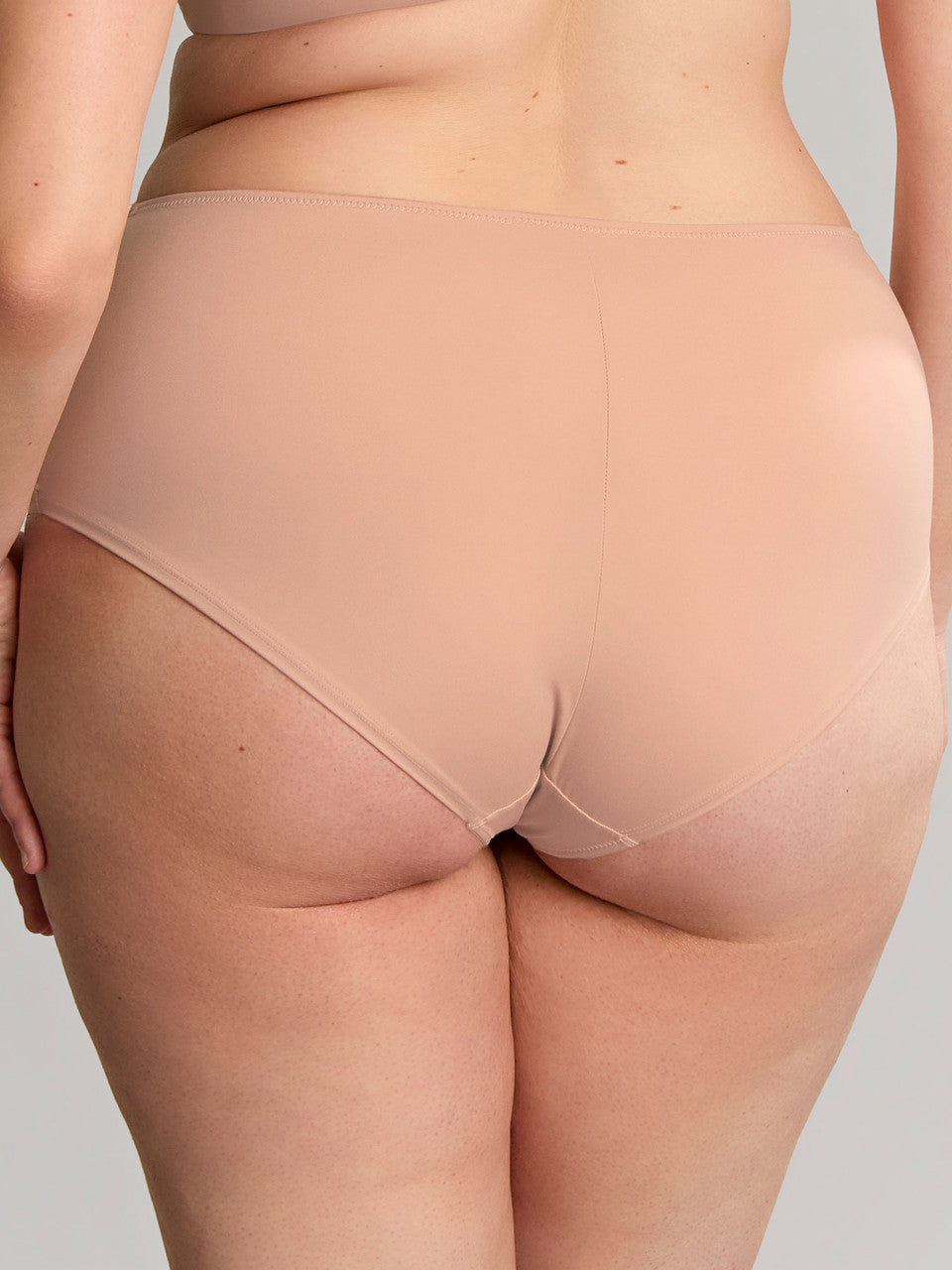 Back view of the beige Bliss Deep Brief on a model, showing smooth rear coverage