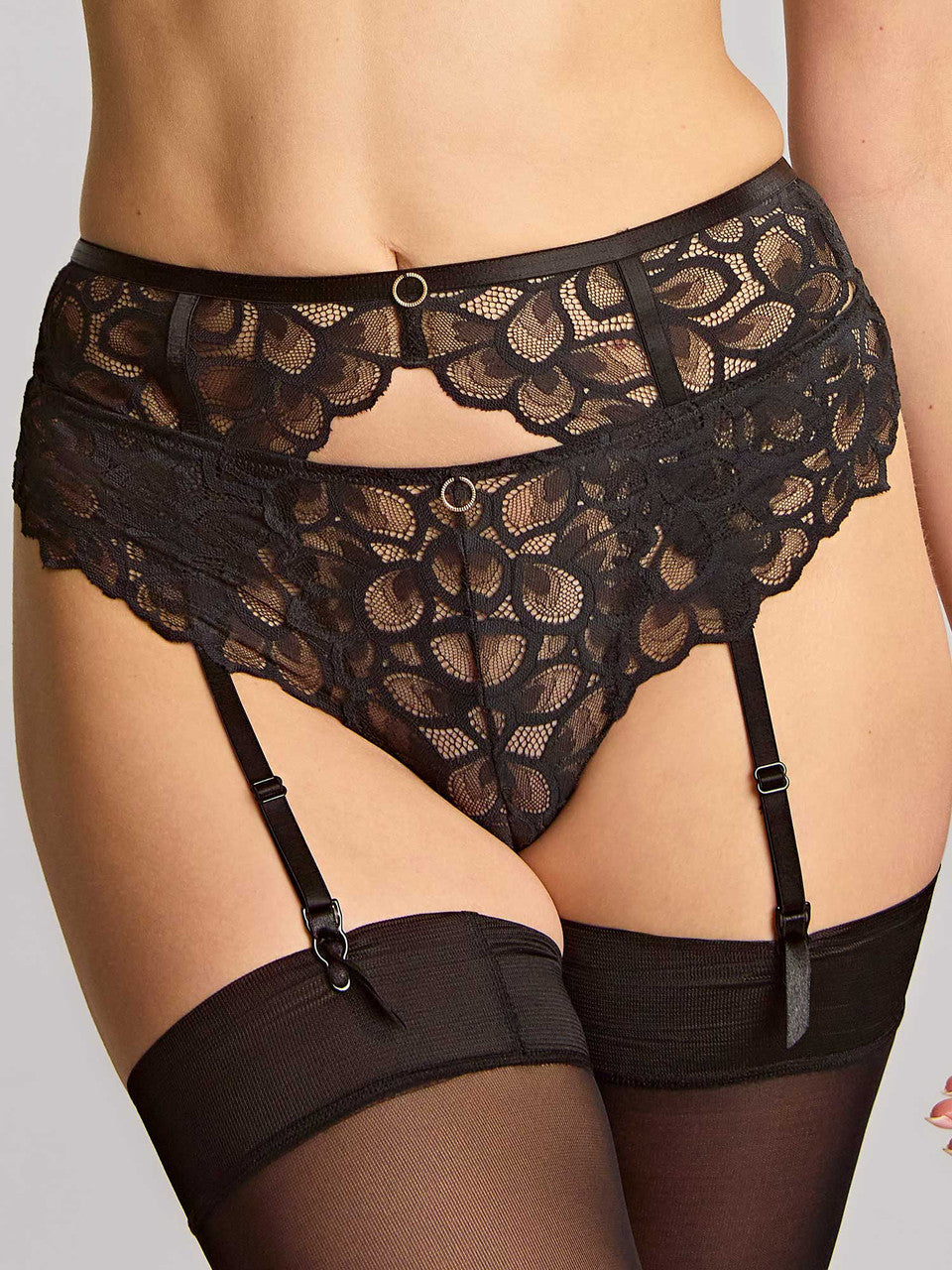 Black lace lingerie set with garters on a neutral background