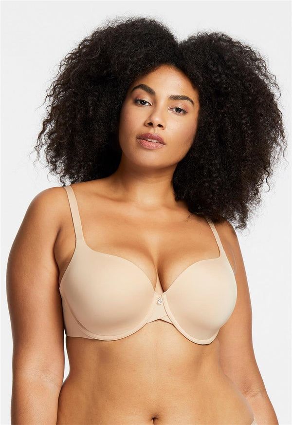 Woman wearing a beige bra against a plain background