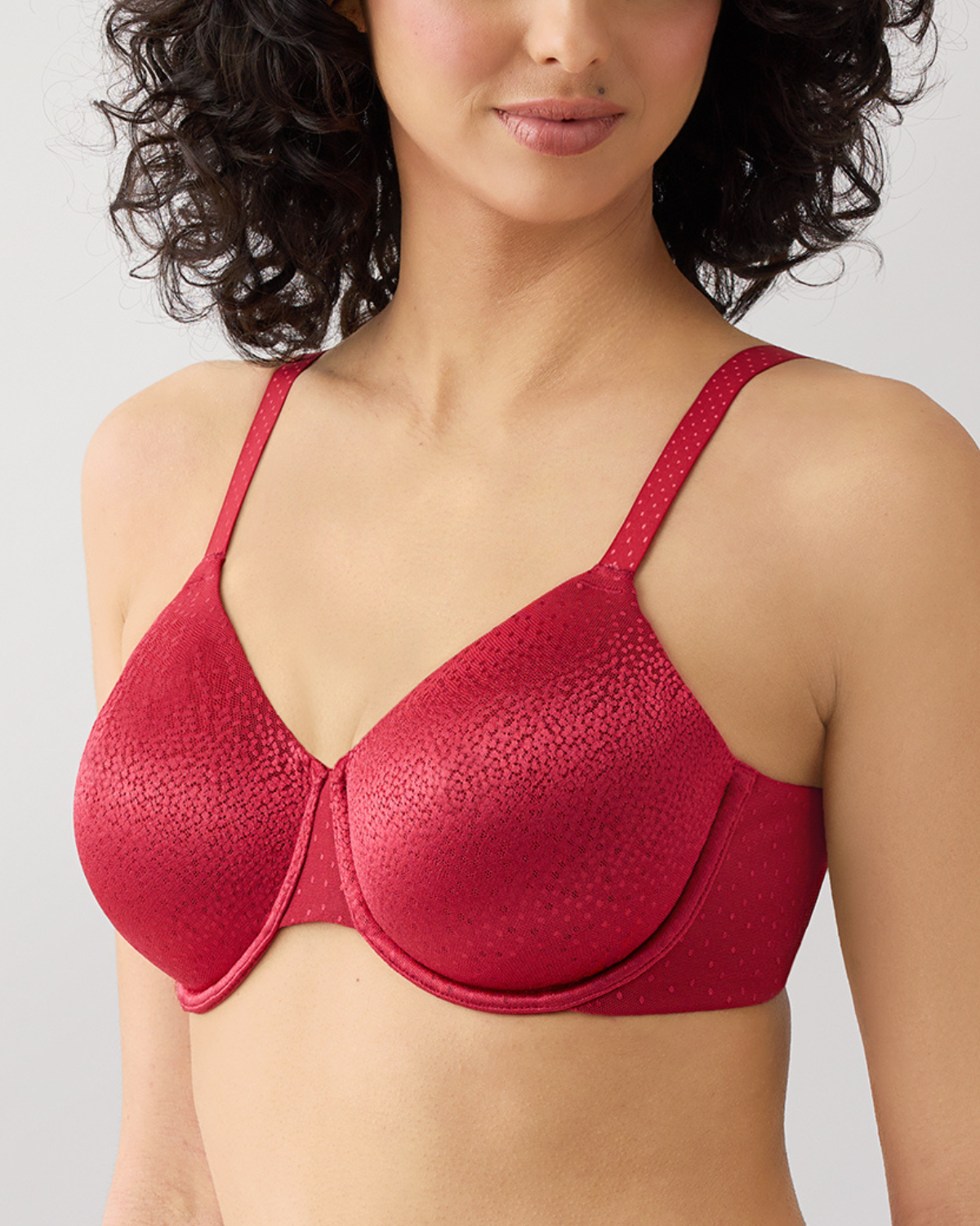 Red bra worn by a model on a plain background