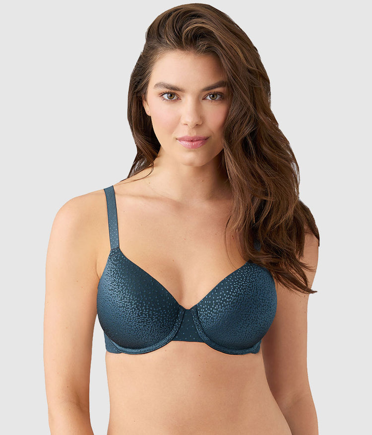 Woman wearing a teal bra against a plain background