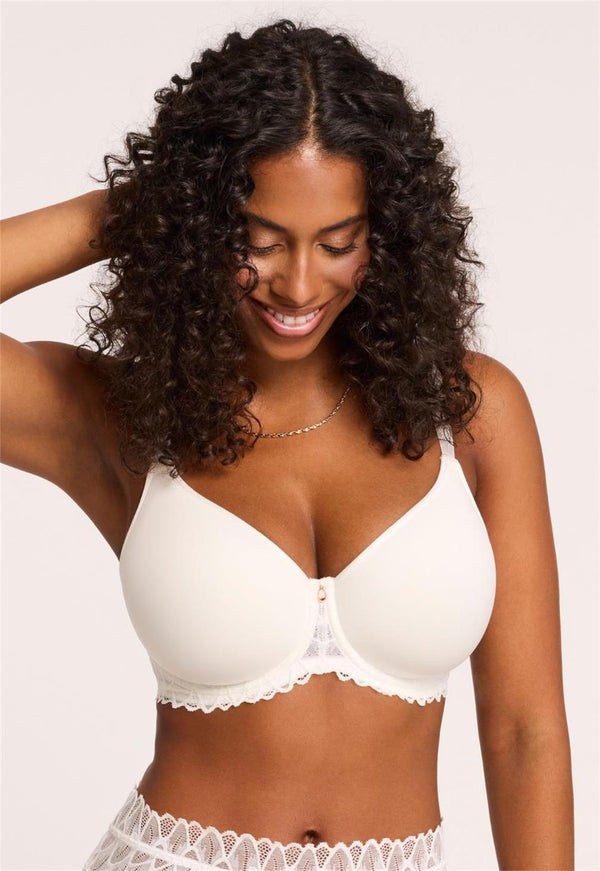 Woman wearing a white bra and underwear set against a plain background