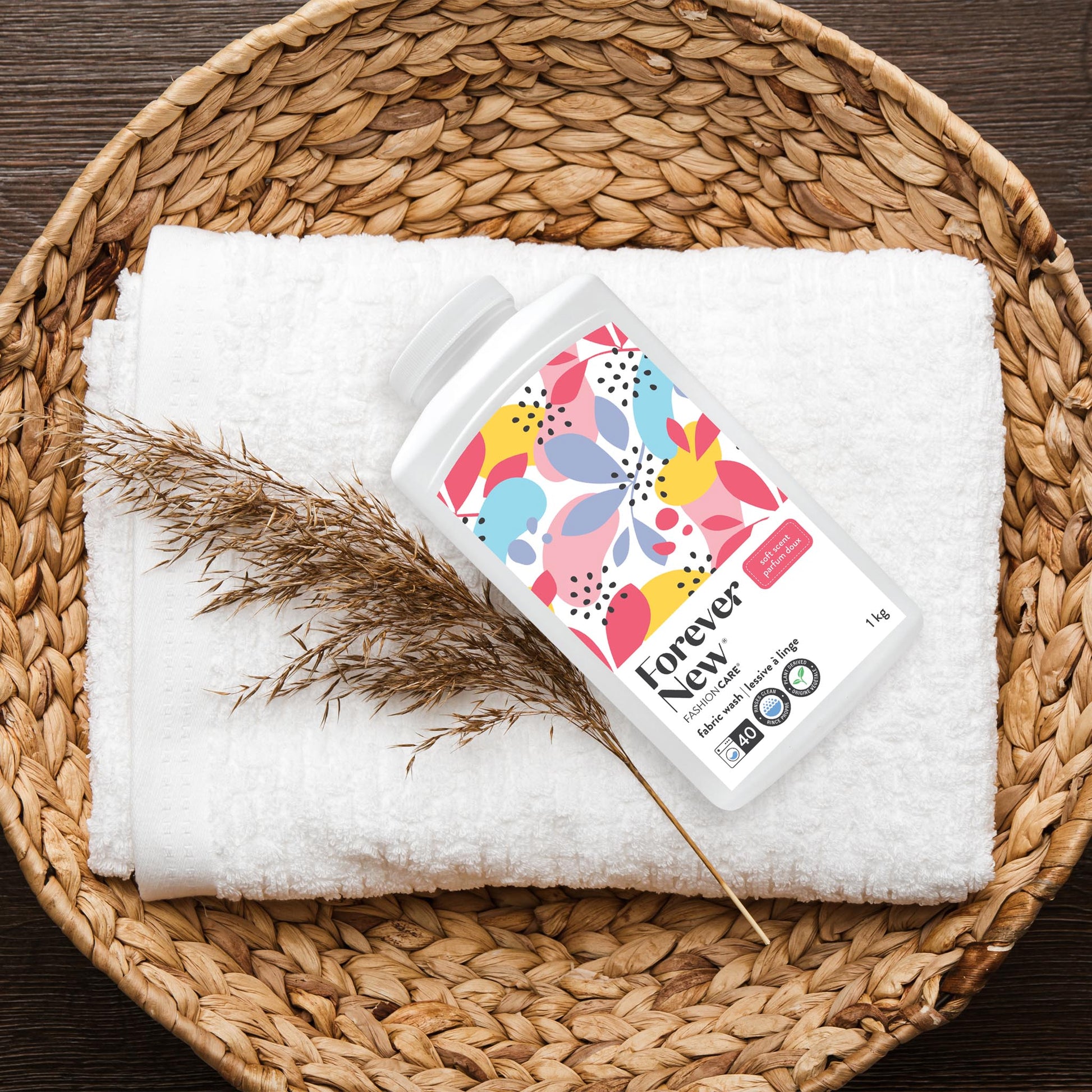 Forever New Powder Large Fabric Wash Soft Scent on top of folded towel in a wicker basket