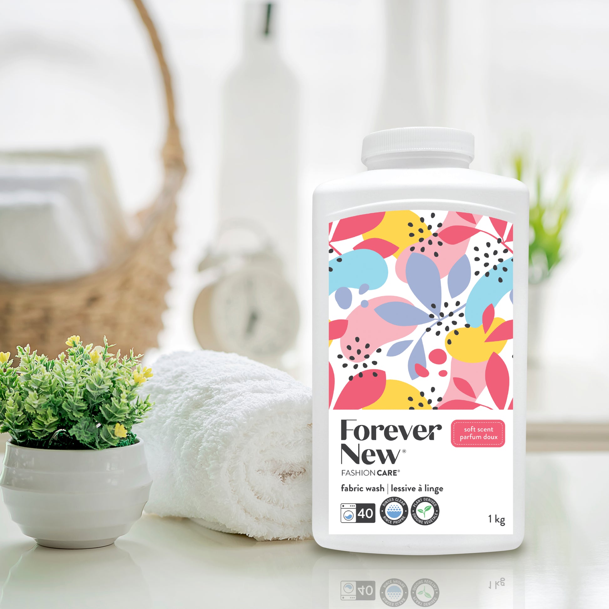 Forever New Powder Large Fabric Wash Soft Scent next to a folded towel on a counter