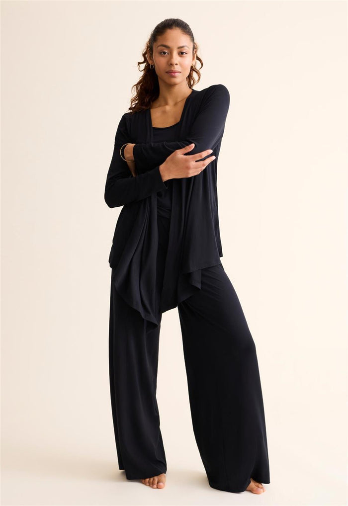 Woman wearing a black outfit on a beige background