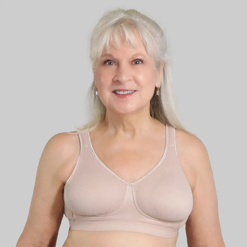 Woman wearing a beige bra against a plain background