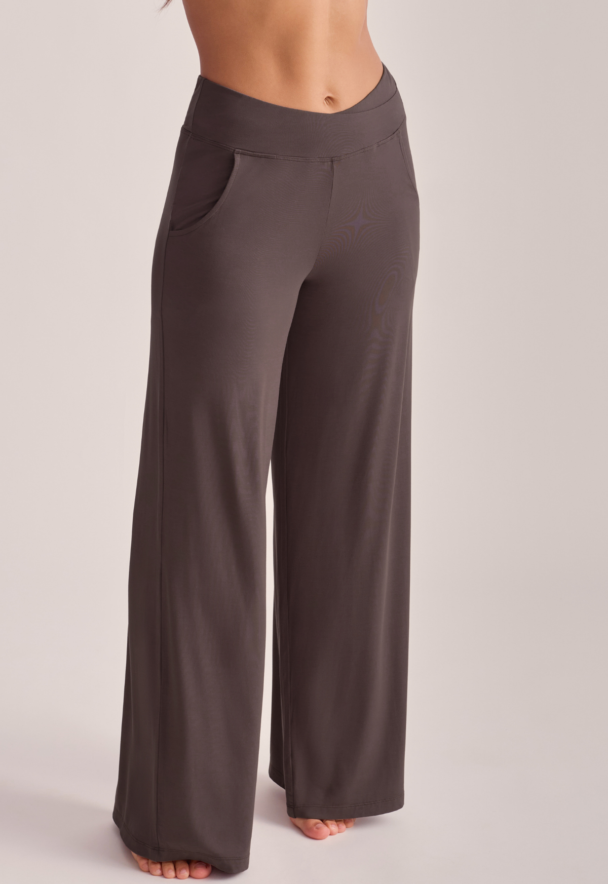 A person wearing dark taupe wide-leg pants.