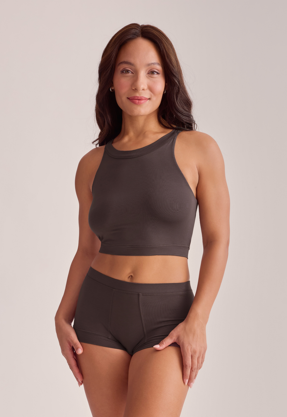 A woman modeling a dark brown crop top and matching boy shorts, front view