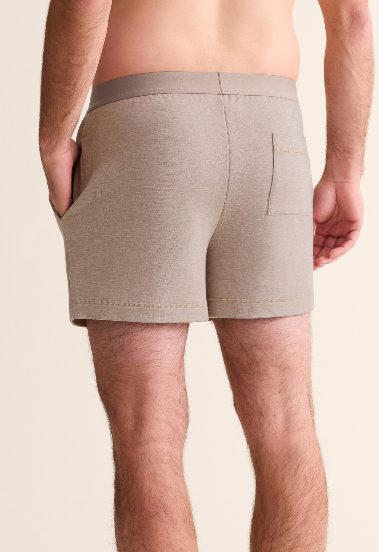Beige boxer briefs worn by a person on a beige background