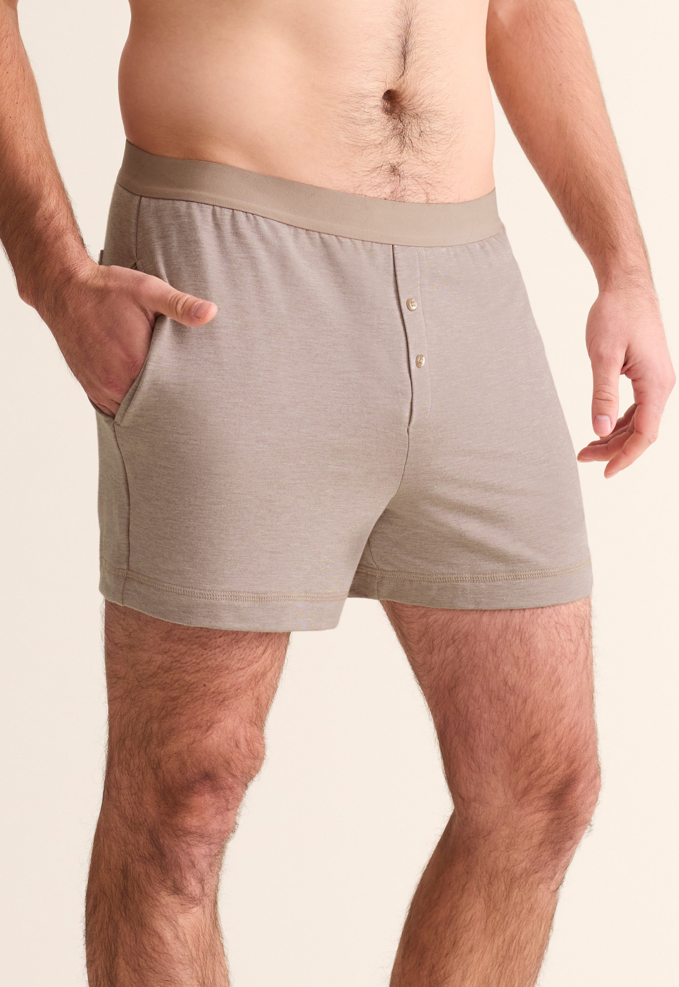 Man wearing beige boxer shorts on a plain background