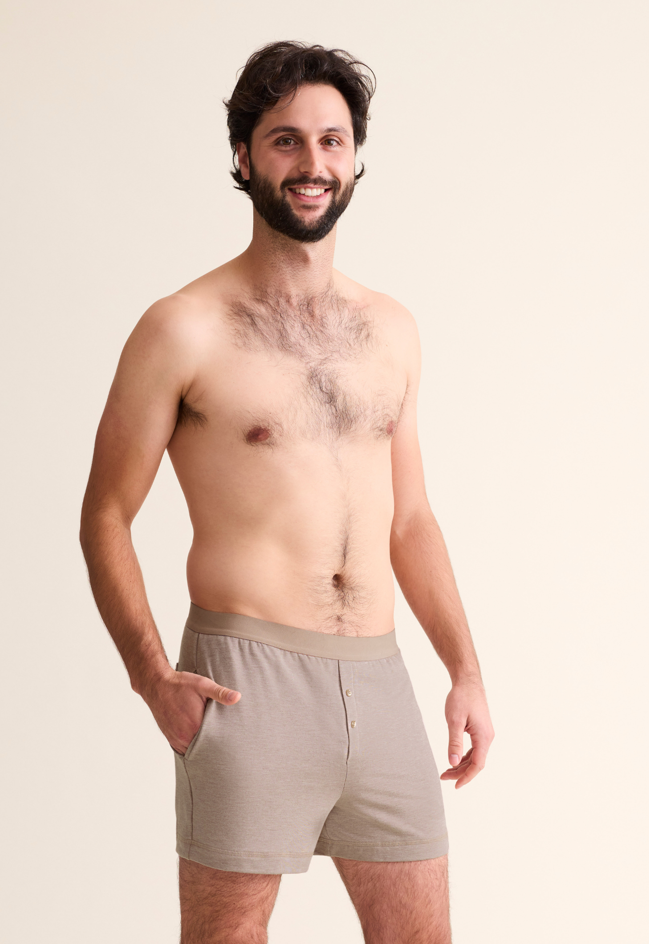 Man wearing beige boxer briefs against a plain background