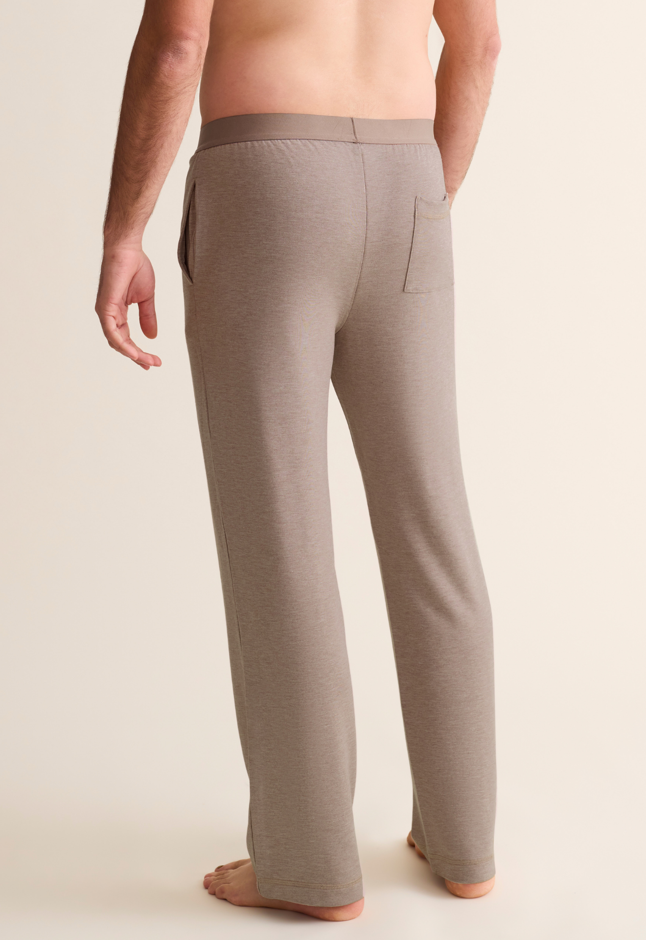 Man wearing beige lounge pants on a plain background