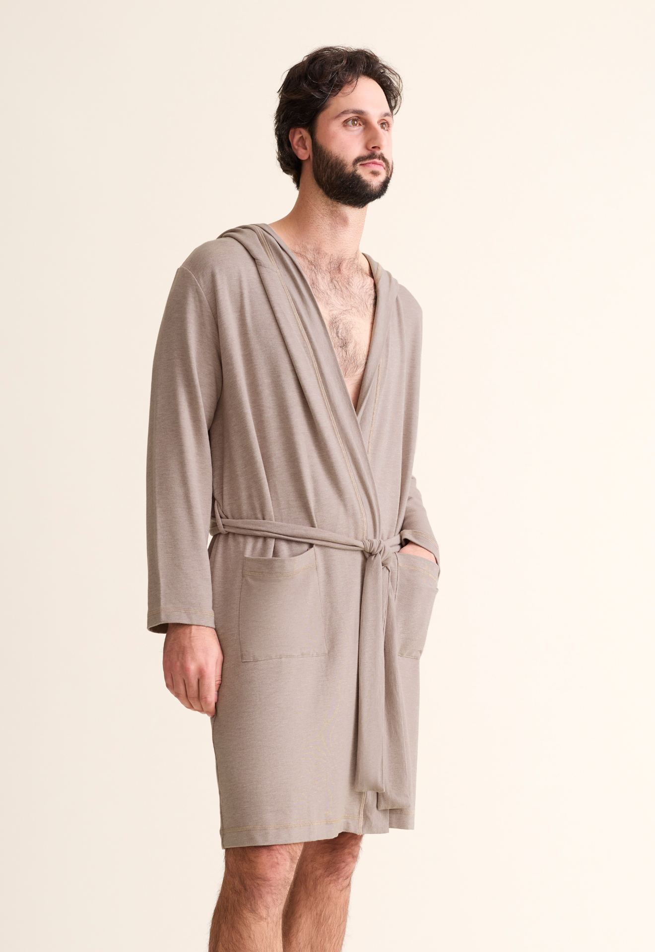 Man wearing a beige robe against a plain background