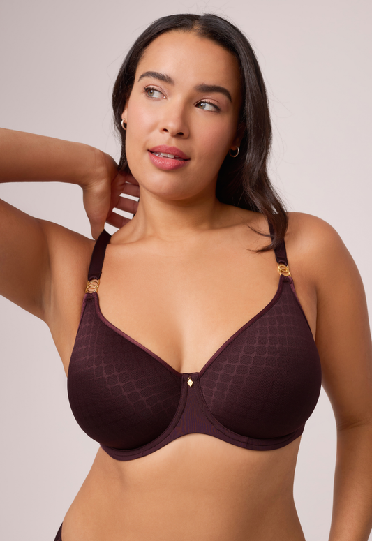 Woman wearing a dark brown bra against a plain background