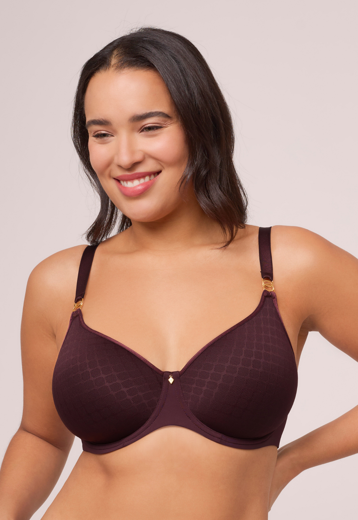 Woman wearing a dark brown bra against a plain background