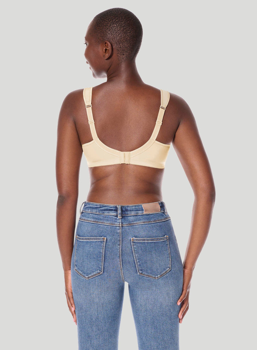 Person wearing Isadora wireless beige bra and blue jeans on a plain background