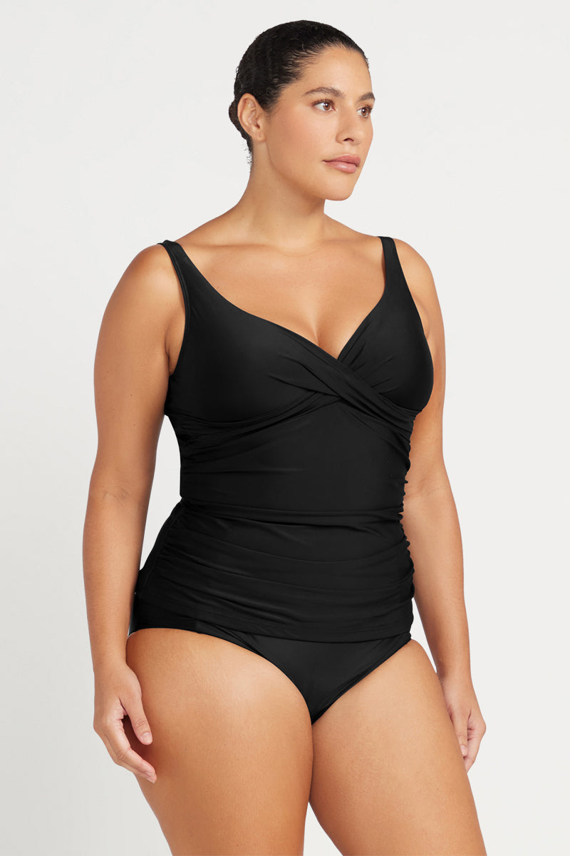Woman wearing a black swimsuit against a white background