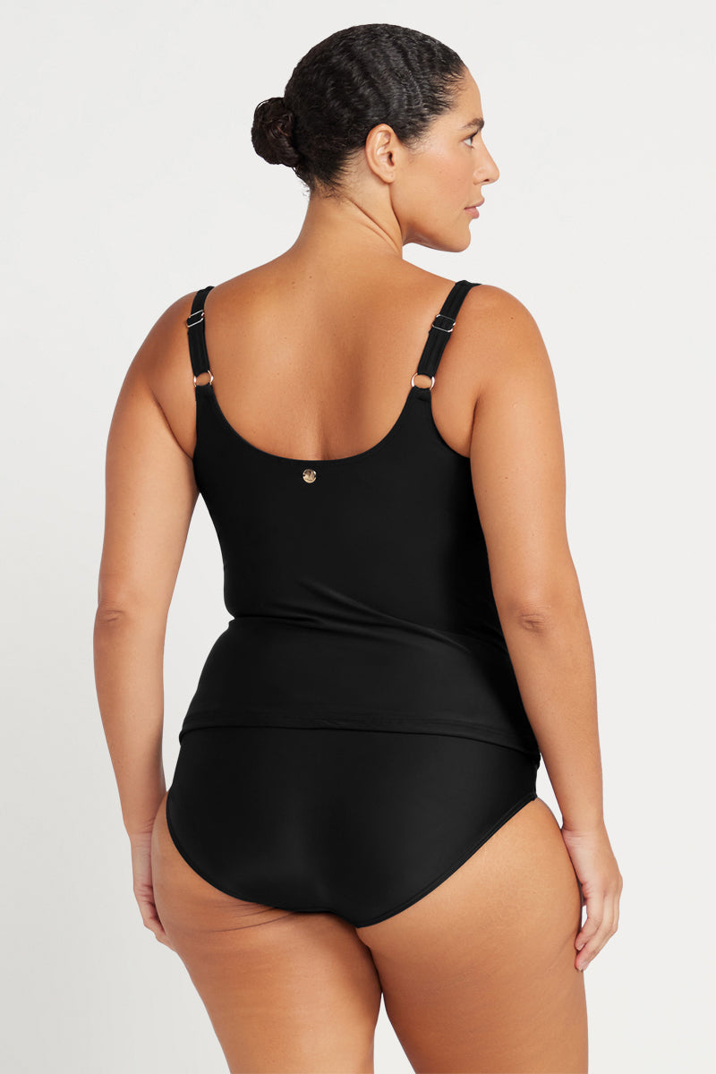 Woman wearing a black swimsuit against a white background