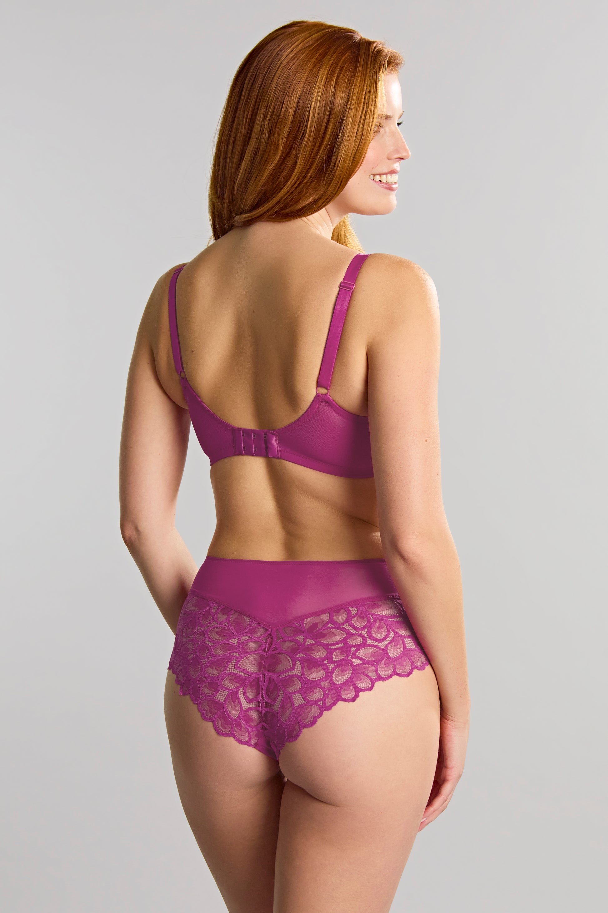 Woman wearing a purple lingerie set on a gray background
