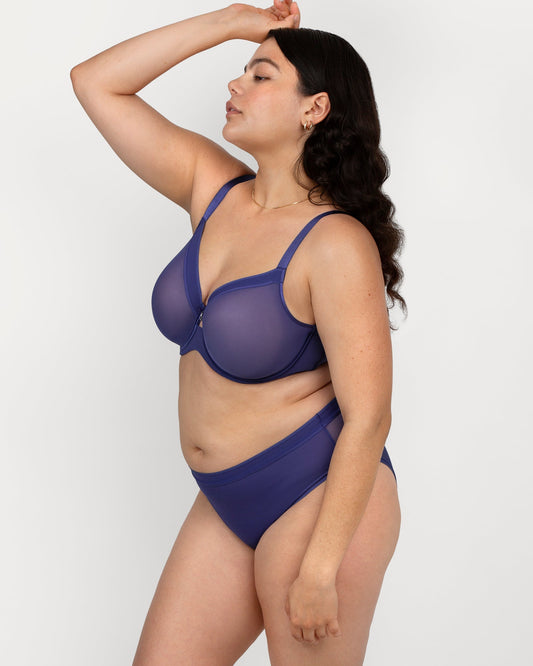 Woman wearing a blue bra set against a white background