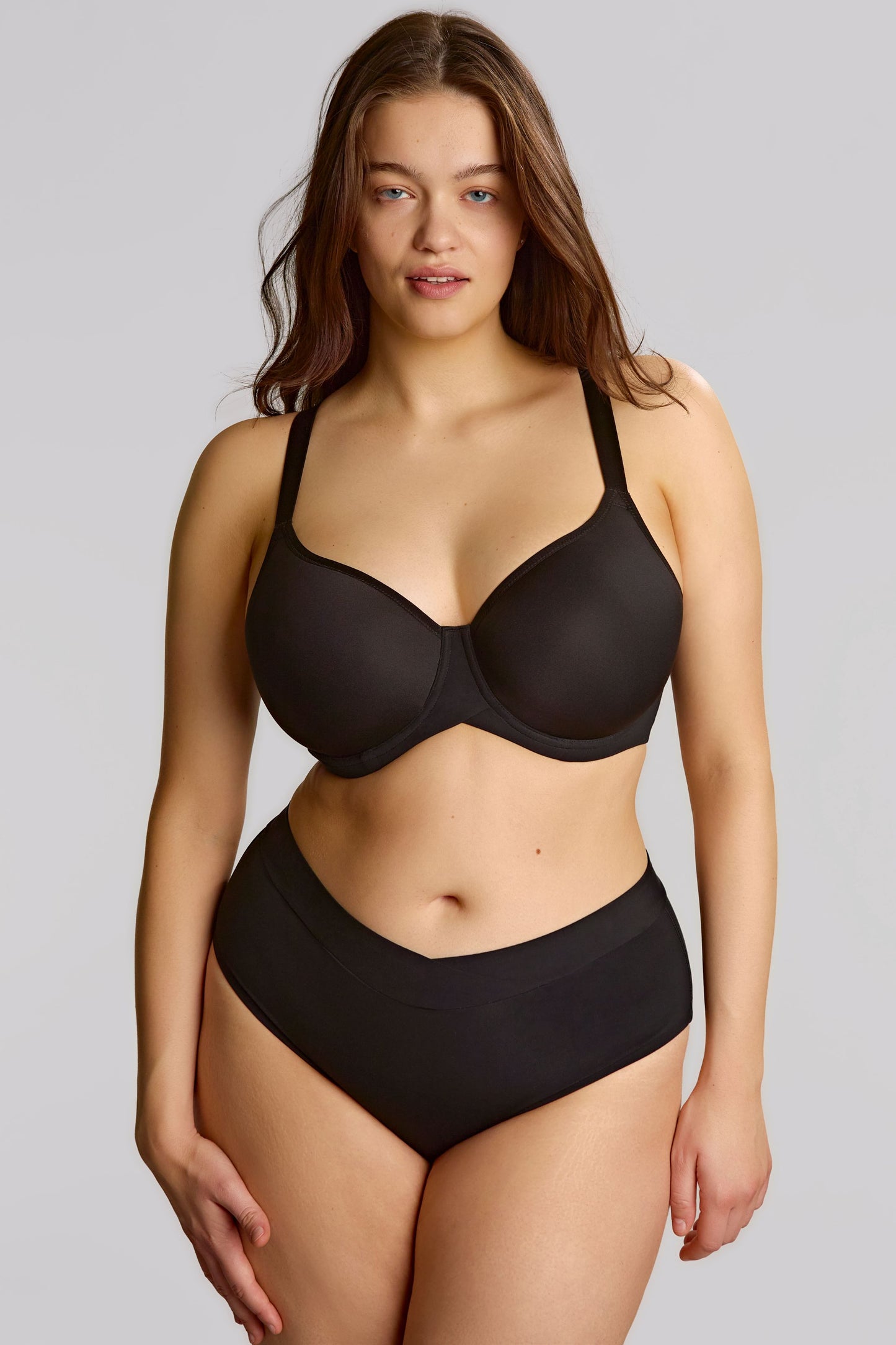 Woman wearing a black lingerie set on a plain background