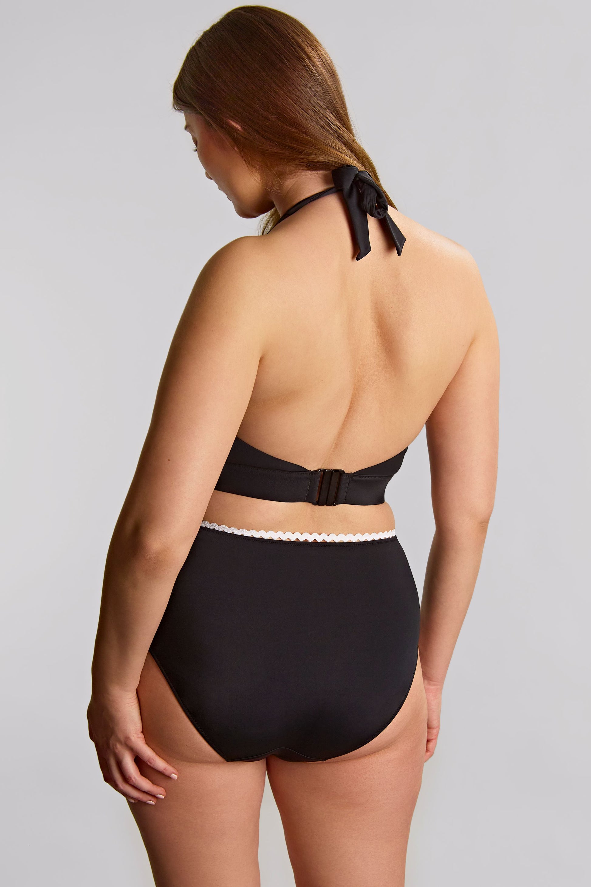 Woman wearing a black bikini with a gray background