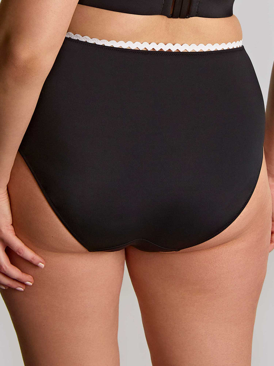 Black high-waisted bikini bottom with white lace trim on a neutral background