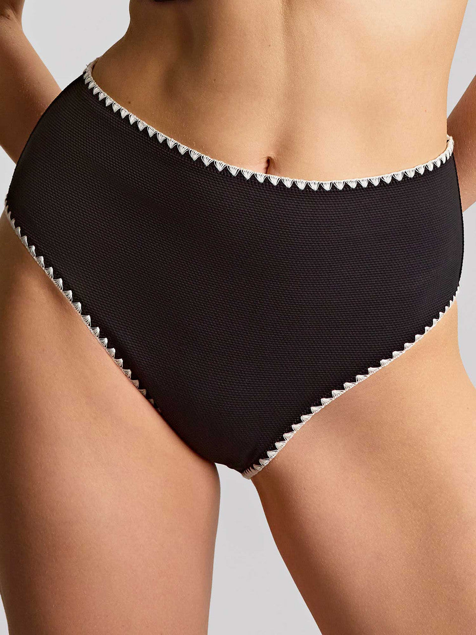 Black high-waisted bikini bottom with white trim on a neutral background