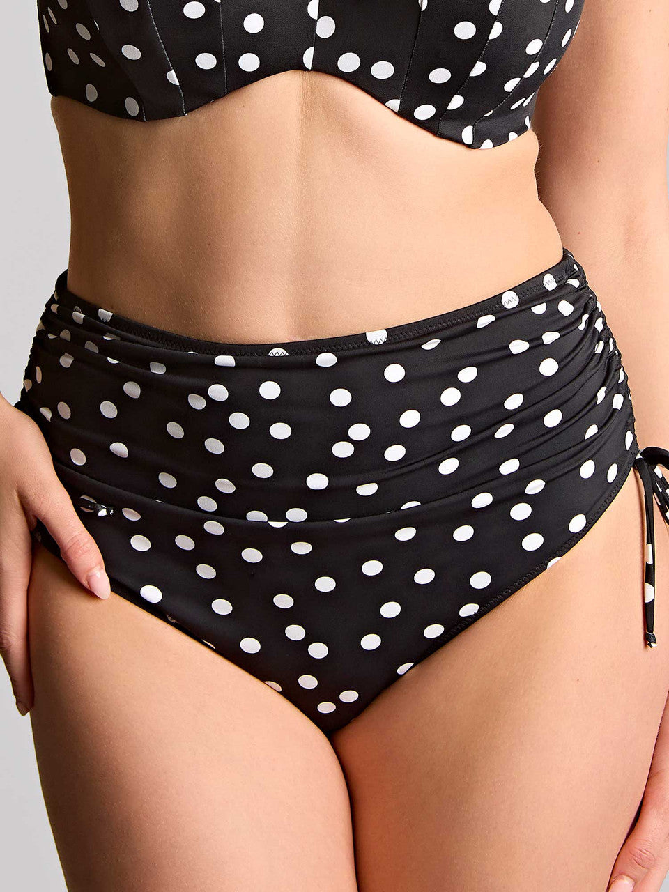 Black and white polka dot mid rise adjustable bikini set on a neutral background