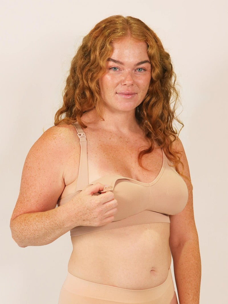 Woman wearing a beige compression garment against a plain background