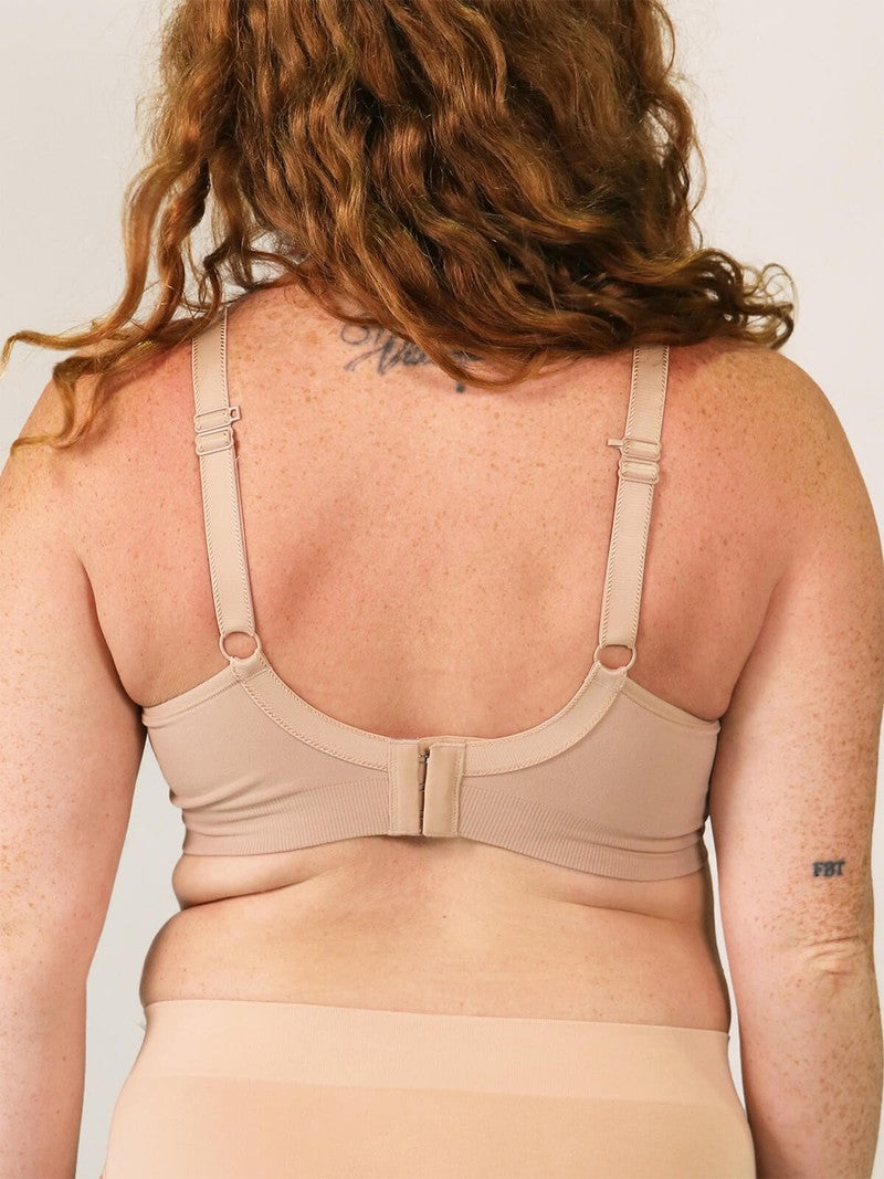 Beige bra worn by a person on a plain background