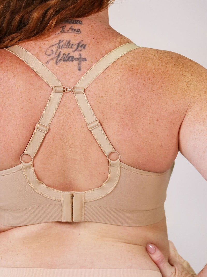 Beige strapless bra worn by a person with a tattoo on their back.