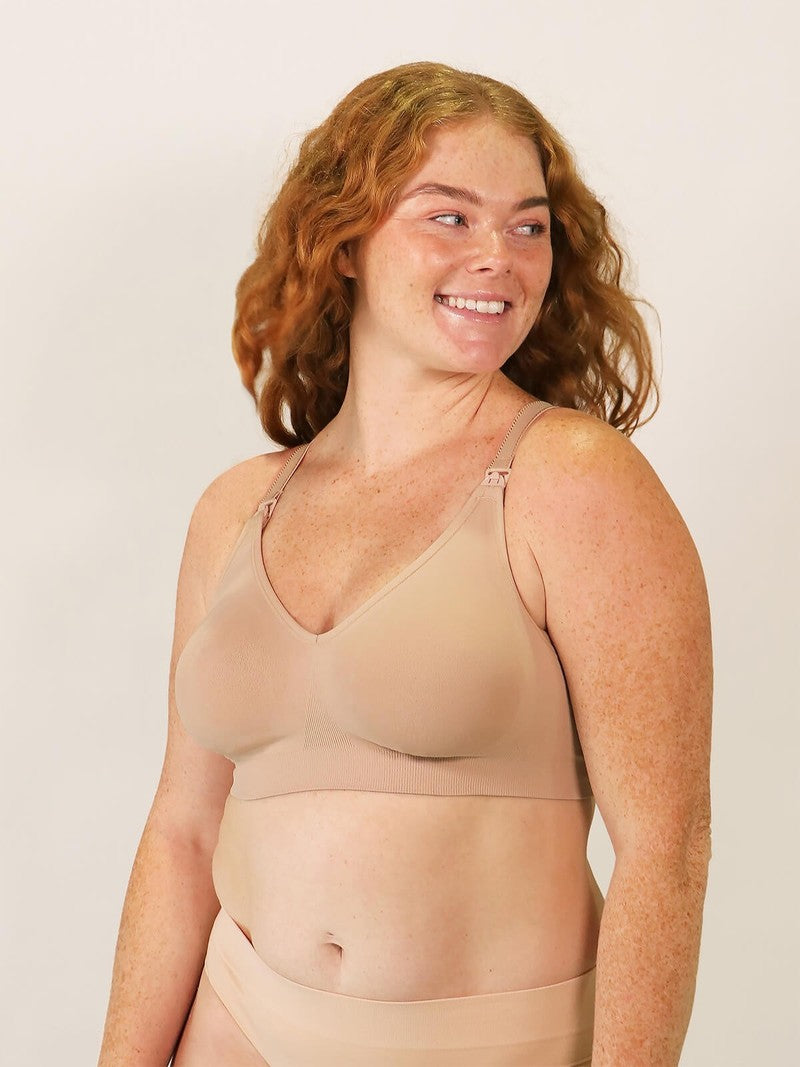 Woman wearing a beige bra and underwear set against a plain background