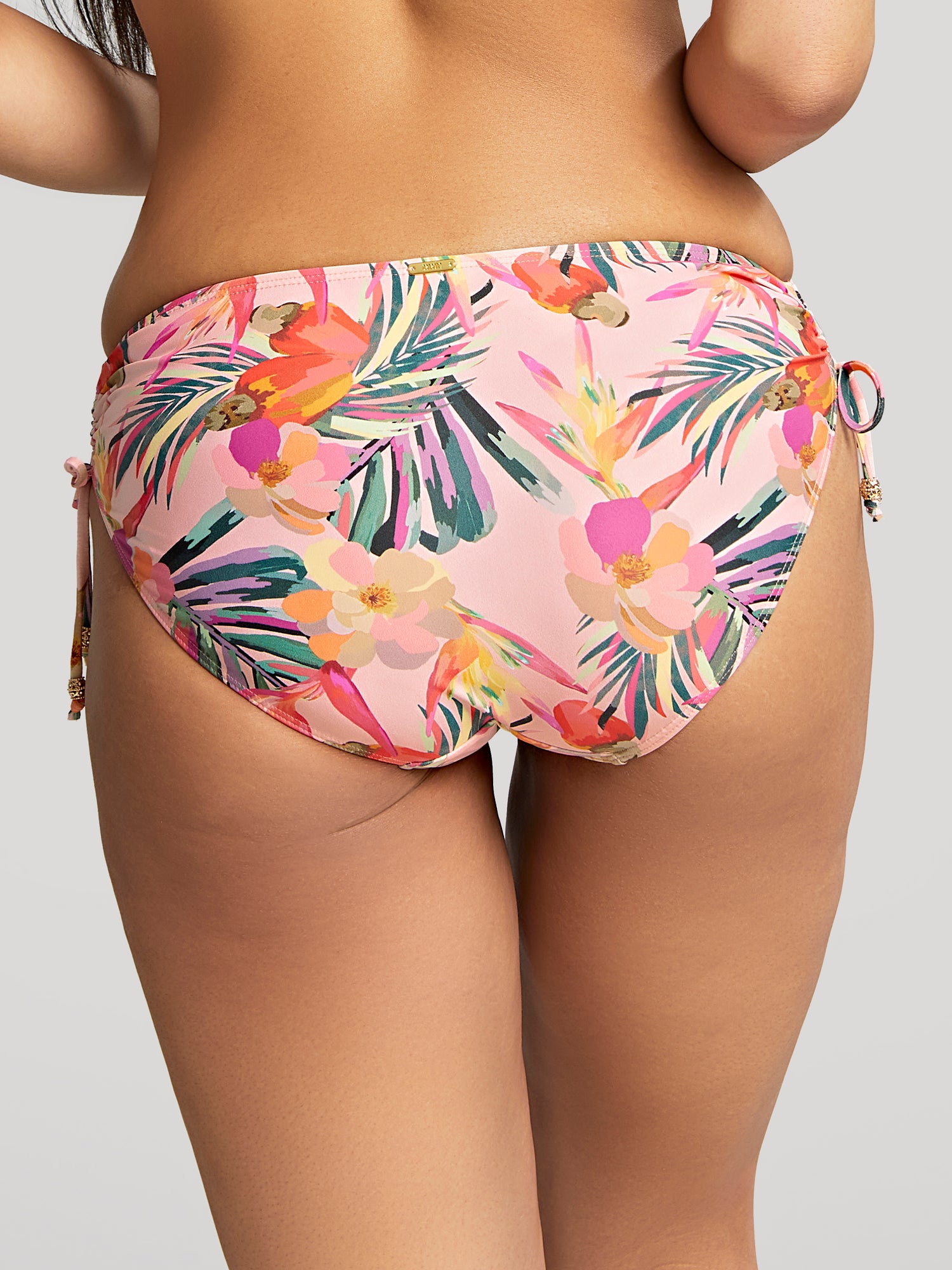 Model is wearing the Paradise Midi Tie Side Pant in pink tropical. Close up in back view.